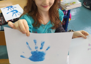 dziewczynka z odciśniętą dłonią na niebiesko